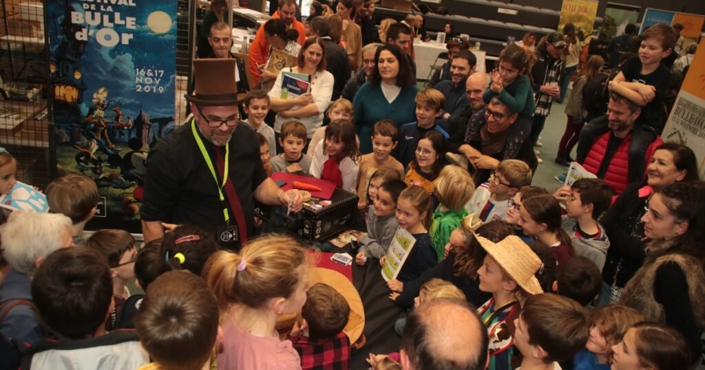 Stéphane Le Magicien captive un public d'enfants et de parents lors d'un spectacle de magie au festival de la Bulle d'Or